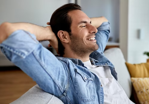 Imagem com um homem se sentindo confortavel com o tratamento, pois não precisa se preocupar em ficar removendo dentarua ou proteses já que o implante não existe essa possibilidade